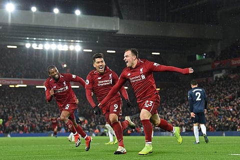 Liverpool's Swiss midfielder Xherdan Shaqiri (C) celebrates with Liverpool's Dutch midfielder Georginio Wijnaldum (L) and Liverpool's Brazilian midfielder Roberto Firmino (2nd L) after scoring their third goal during the English Premier League football ma