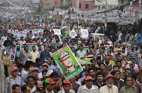 Bangladesh's Jatiya Oikya Front supporters display pictures of former president Ziaur Rahman and former prime minister Khaleda Zia as they march in a rally to mark the Victory Day in Dhaka on Sunday. (Photo | AP)