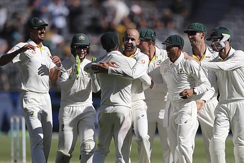 Australian players congratulate bowler Nathan Lyon, centre, after he claimed the wicket of India's Virat Kohli during play in the second cricket test between Australia and India in Perth, Australia, Monday, Dec. 17, 2018. | AP