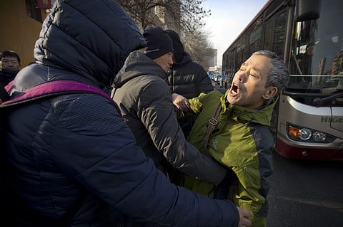Plainclothes security officers take away a supporter of Chinese human rights lawyer Wang Quanzhang near the Secondary Intermediate People's Court of Tianjin in North-East China. (AP Photo)