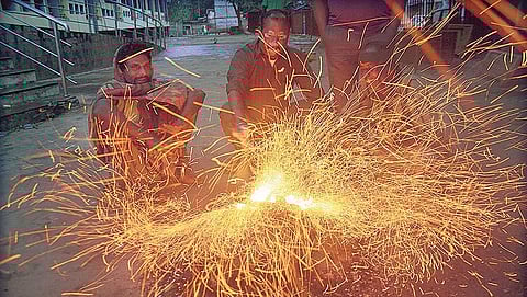 People warming themselves to beat the cold beside a road in Bhubaneswar on Tuesday morning | Express