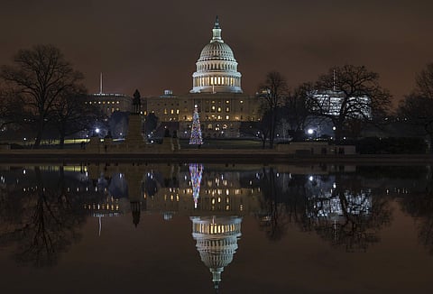 The Capitol is mirrored in the Reflecting Pool in Washington, as a partial government shutdown heads into a second week, Friday night, Dec. 28, 2018. (Photo | AP)