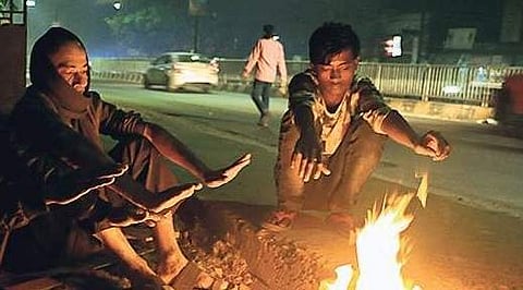 People warm themselves near a bonfire in Bhubaneswar. (Irfana | EPS)