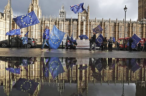 Protestors are reflected in a puddle as they wave European flags to demonstrate against Brexit in front of the Parliament in London. (Photo | AP)