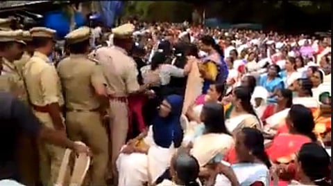 Video screen grab of protesting women being escorted out of the venue by police