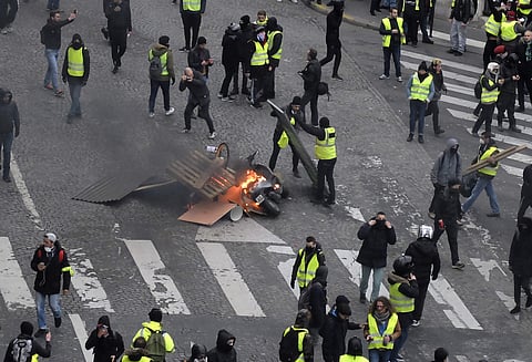 Demonstrators set up a barricade Saturday, Dec. 8, 2018 in Paris. Crowds of yellow-vested protesters angry at President Emmanuel Macron and France's high taxes tried to converge on the presidential palace Saturday, some scuffling with police firing tear g