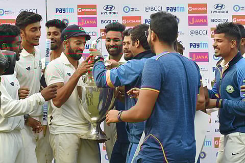 Vidarbha team captain Faiz Fazal along with teammates celebrate with the trophy after winning the Ranji Trophy final match against Delhi. | PTI