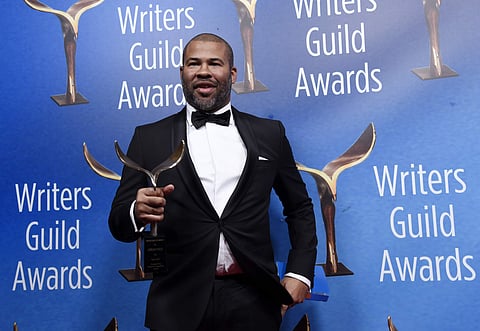 Jordan Peele, writer/director of 'Get Out,' poses with his Outstanding Original Screenplay award backstage at the 2018 Writers Guild Awards. | AP