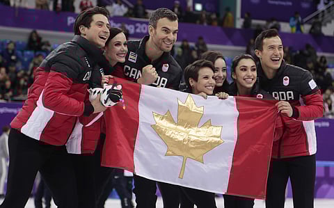 The Canadian team pose for a group photo following the Venue Ceremony after winning the gold medal in the figure skating team event in the Gangneung Ice Arena at the 2018 Winter Olympics. (AP)