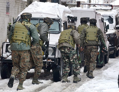 Security personnel take positions during an encounter with the militants who were sheltering in a building near a CRPF camp at Karra Nagar in Srinagar on Monday. | PTI
