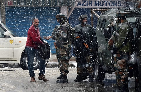Army personnel frisk a man near the site of gun-battle between the security forces personnel and militants at Karan Nagar in Srinagar on Monday. | PTI