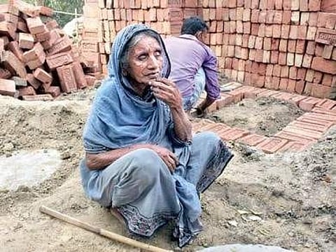 Rahima Bewa sitting in front of the toilet which is being constructed at her residence in Nowdapada village in Daulatabad in Murshidabad district of West Bengal. | Express Photo Service