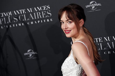 Dakota Johnson poses during a photocall for the world premiere of 'Fifty Shades Freed - 50 Nuances Plus Claires' at Salle Pleyel in Paris, Tuesday, Feb. 6, 2018. | AP