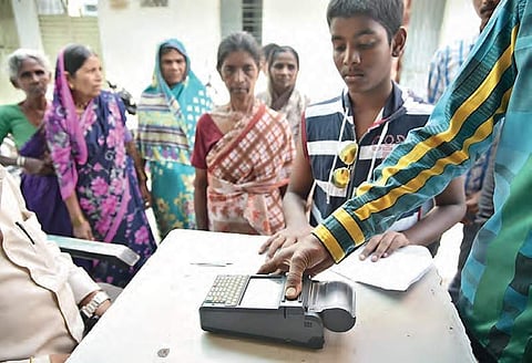 Beneficiaries using bio-metric system at a ration shop in Hyderabad on Sunday | r satish babu