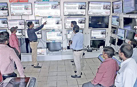 Staff and customers catch highlights of the Union Budget at a shop in Bhubaneswar on Thursday | SHAMIM QURESHY