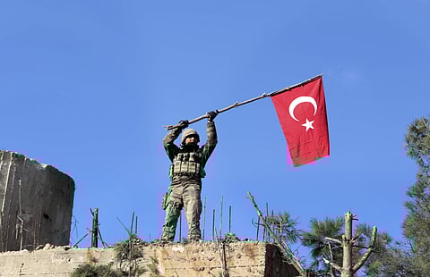 File: A soldier waves a Turkish flag as Turkish troops secure Bursayah hill, which separates the Kurdish-held enclave of Afrin from the Turkey-controlled town of Azaz | AP