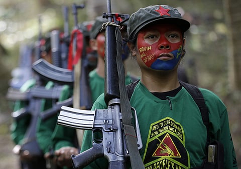 Members of the New People's Army communist rebels with face painted to conceal their identities, march with their firearms before a news conference held at their guerrilla encampment tucked in the harsh wilderness of the Sierra Madre mountains southeast o