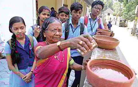 Padma Shri Lakshmikutty Amma fills a mud pot on Wednesday as part of the ‘Kilikkudam Project’ announced by the North Paravoor municipality | K Shijith