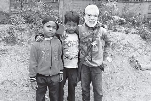 A child sports a mask of PM Narendra Modi in poll-bound Meghalaya. | Express