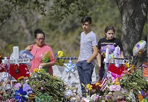Mourners bring flowers as they pay tribute at a memorial for the victims of the shooting at Marjory Stoneman Douglas High School on Sunday, Feb. 25, 2018, in Parkland, Fla. (Associated Press)