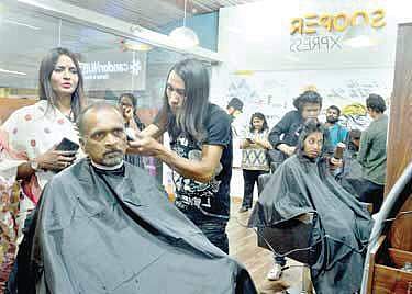 Mahendra Jain, Managing Director of BMRCL, gets a haircut at the newly opened salon at Trinity Metro station on Sunday. | Pushkar V