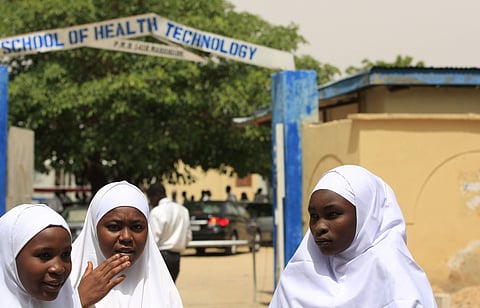 FILE- In this Thursday, June. 6, 2013 file photo, Young women stand in front of a school in Maiduguri, Nigeria. | AP