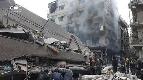 Syrians search for victims under the rubble of a destroyed building that attacked by Syrian government forces airstrikes, in Ghouta, a suburb of Damascus, Syria. | AP