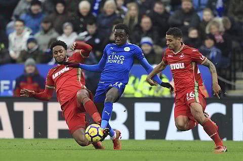Swansea City's Leroy Fer, left, and teammate Martin Olsson battle with Leicester City's Fousseni Diabate, centre during the English Premier League soccer match between Leicester City and Swansea City. | AP