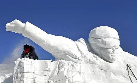 A worker uses a chainsaw to work on a large ice sculpture being built near the Pyeongchang Olympic Plaza as preparations continue for the 2018 Winter Olympics in Pyeongchang. | AP