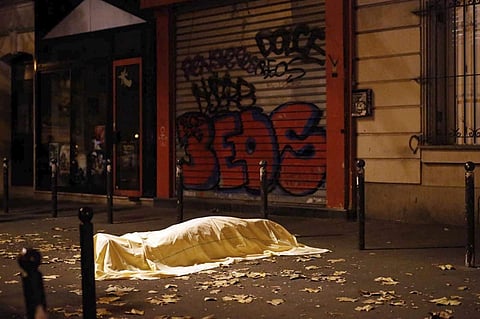 In this Friday Nov. 13, 2015 file photo a victim under a blanket lays dead outside the Bataclan theater in Paris. (Photo | Associated Press)