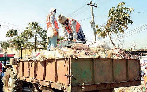 Sanitation workers clean the garbage left behind by devotees attending the Medaram Jatara in Warangal on Thursday