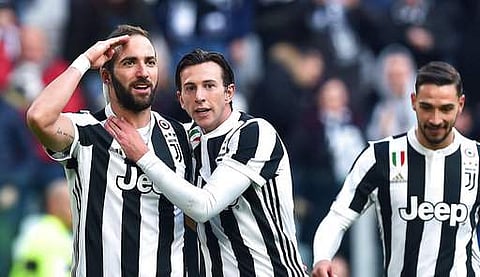 Juventus' Gonzalo Higuain, left, celebrates with his teammate Federico Bernardeschi after scoring a goal during the Italian Serie A soccer match between Juventus and Sassuolo at the Allianz Stadium in Turin. | Photo: AP