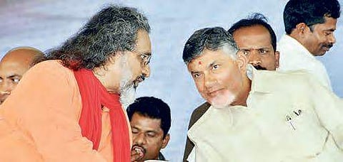 Swami Amritaswarupananda Puri speaking to Naidu during Amrita varsity’s foundation stone-laying ceremony in Guntur, on Wednesday | Express