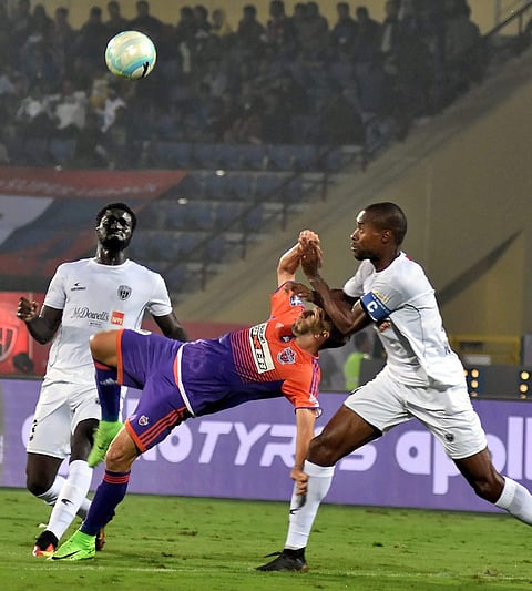 Players of North East United FC White Jersey play against FC Pune City Purple-Orange jersey during the ISL football match at Indira Gandhi Athletic Stadium Sarusajai in Guwahati on Wednesday. | Photo: PTI