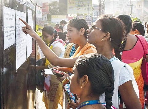 Students throng the notice board before taking the Intermediate exams