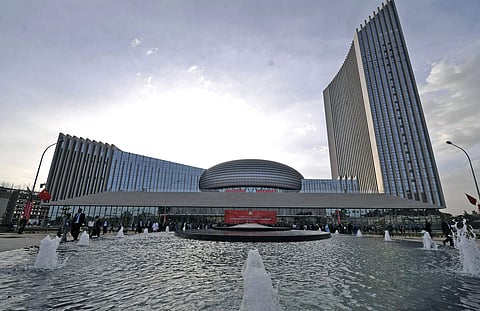 In this photo provided by China's Xinhua News Agency people gather before a red banner written in English and Chinese set up for the opening ceremony of the African Union Conference Center in Addis Ababa, Ethiopia, on Jan. 28, 2012. (AP)