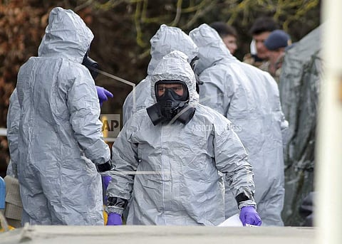 Investigators in protective clothing prepare to move an ambulance at the South Western Ambulance Service station in Harnham, near Salisbury, England, as police and members of the armed forces probe the suspected nerve agent attack on Russian spy double ag