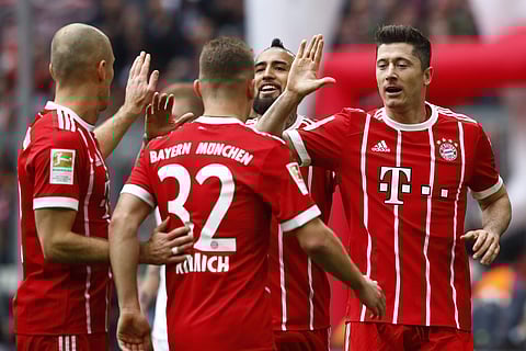 Bayern's Robert Lewandowski, right, celebrates with team mates after scoring his side's second goal during the German Soccer Bundesliga match with Hamburger SV | Photo: AP