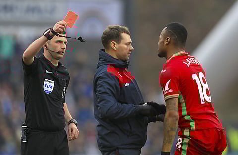 Swansea City's Jordan Ayew is shown the red card by referee Michael Oliver during the game against Huddersfield Town. (Photo | AP)