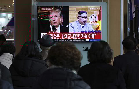 People watch a TV screen showing North Korean leader Kim Jong Un and U.S. President Donald Trump, left, at the Seoul Railway Station in Seoul, South Korea. | AP