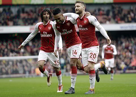Arsenal's Shkodran Mustafi, right, celebrates after scoring his side's opening goal with Arsenal's Pierre-Emerick Aubameyang, center and Arsenal's Mohamed Elneny during the English Premier League soccer match between Arsenal and Watford at the Emirates st