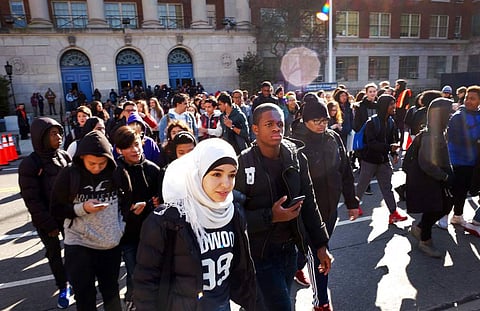 Hundreds of students walk out of Midwood High School as part of a nationwide protest against gun violence. (Photo | AP)