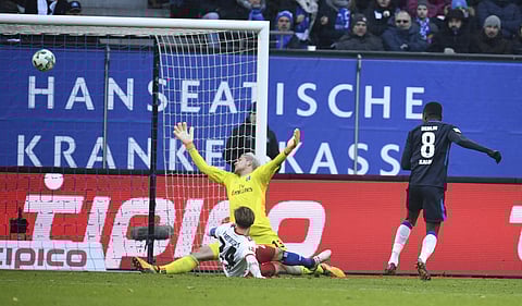 Berlin's Salomon Kalou, right, scores against Hamburg goalie Julian Pollersbeck, and Gotoku Sakai during the German Bundesliga soccer match between Hamburger SV and Hertha BSC Berlin, in Hamburg, Germany, Saturday, March 17, 2018. | AP