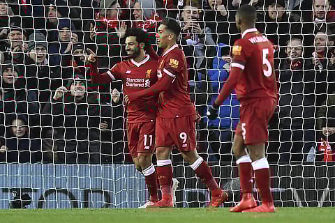 Liverpool's Mohamed Salah, left, celebrates scoring his second goal of the game with teammate Roberto Firmino during the English Premier League soccer match between Liverpool and Watford at Anfield, Liverpool, England, Saturday, March 17, 2018. | AP