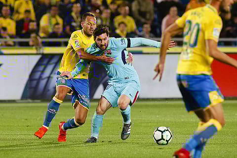 FC Barcelona's Messi, centre, is held by Las Palmas' Dani Castellano, left, during a Spanish La liga soccer match at the Gran Canaria stadium in the Canary island of Las Palmas, Thursday March 1, 2018. | AP