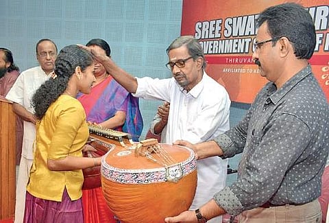 Kochi-based businessman V V Kasthurirangan handing over a Veena to student of Sri Swathi Thirunal College of Music as part of donating musical instruments to the college students in Thiruvananthapuram. College principal Susheela C J is also seen | Manu R