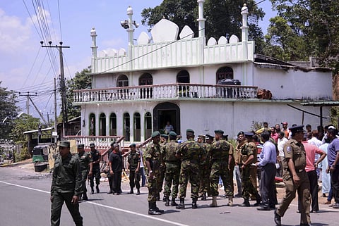 Sri Lanka's army soldiers and police personnel stand near a vandalized Mosque in Digana, a suburb of Kandy. | File AP
