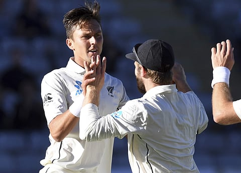 New Zealand's Trent Boult, left, celebrates with captain Kane Williamson after dismissing England's Alastair Cook for 2 during their first cricket test in Auckland, New Zealand. (AP)