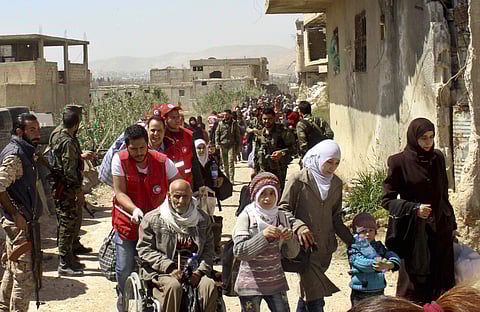 Civilians carrying their belongings leaving towns and villages, in the eastern Ghouta region near Damascus | AP