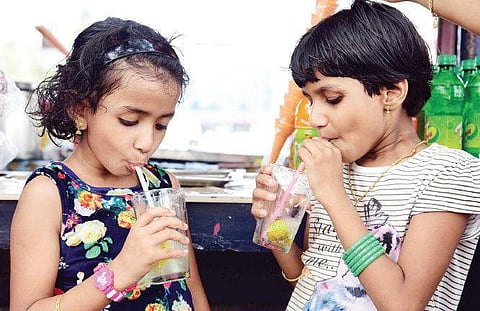 Two girls drinking Kulukki sherbet from a stall at Marine Drive | Albin Mathew
